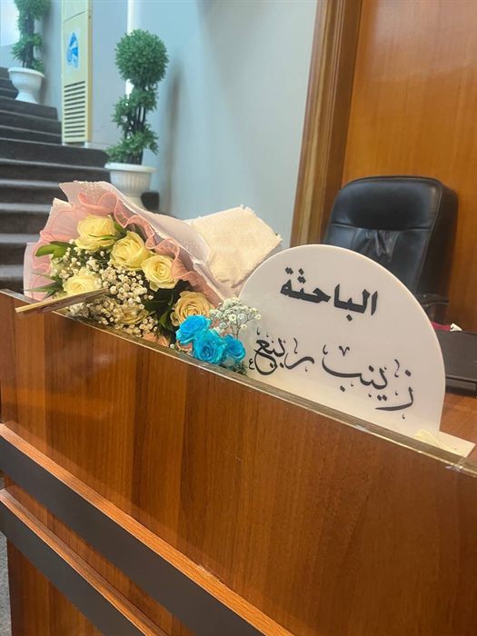 لوحة أكريليك بيضاء نصف دائرية مكتوب عليها بالخط العربي اسم الباحثة